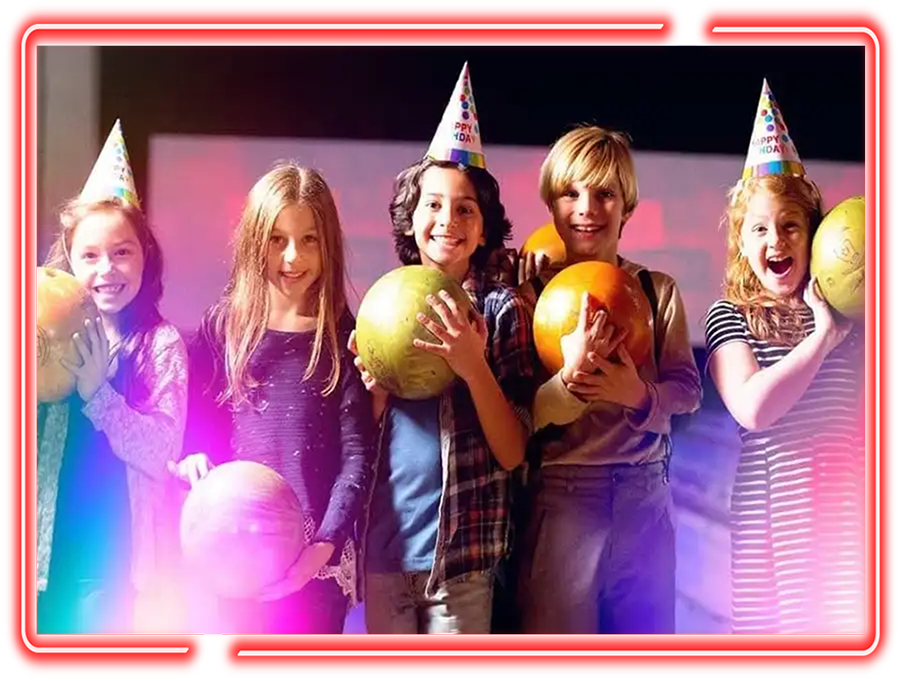 Kids in birthday hats holding bowling balls at a Victory Lanes birthday party in Decatur, IL