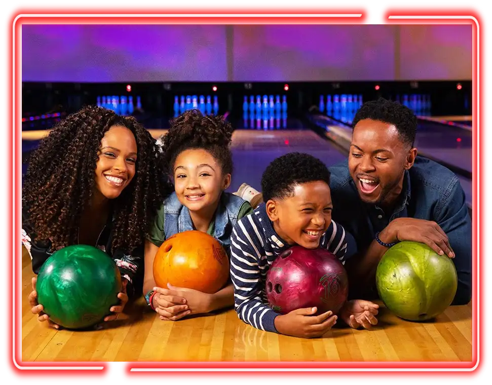 African American Family of four smiling with bowling balls on the lanes at Victory Lanes in Decatur, IL