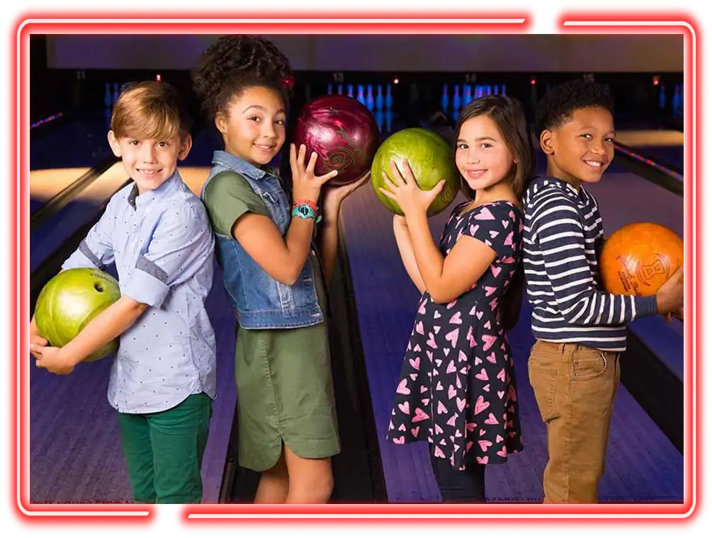 Four kids posing back to back with bowling balls at Victory Lanes in Decatur, IL