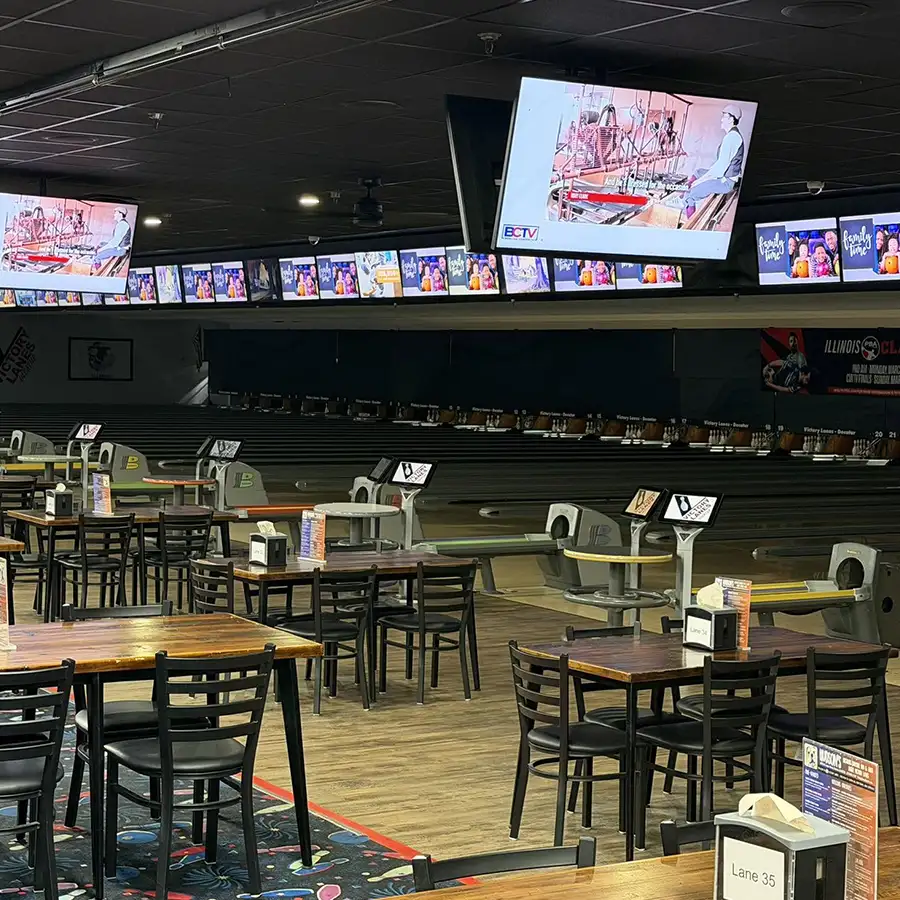 Bowling lanes with overhead TV screens and seating at Victory Lanes in Decatur, IL